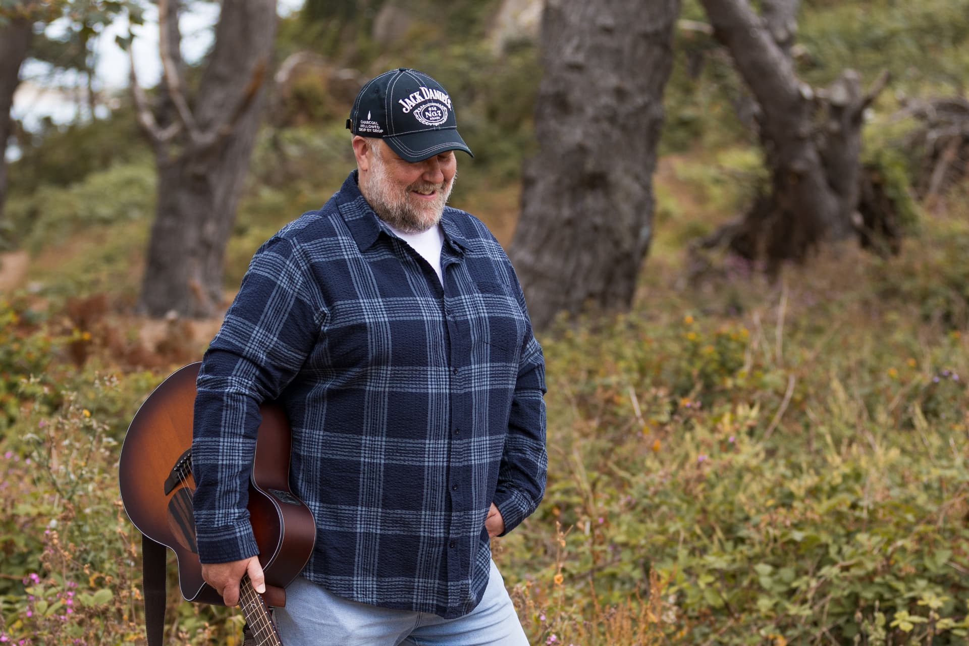Big Gray standing in a field with his guitar